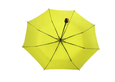 L'ombrello piegante di auto giallo delle signore, piega la fine aperta del manuale assente dell'ombrello